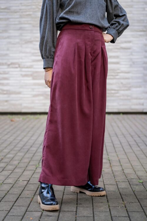 Pantalon ASTAU vu de face, patron de couture femme à plis sur le devant, coupe large et taille haute.